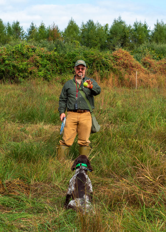 A man doing a dog training demonstration with a dog
